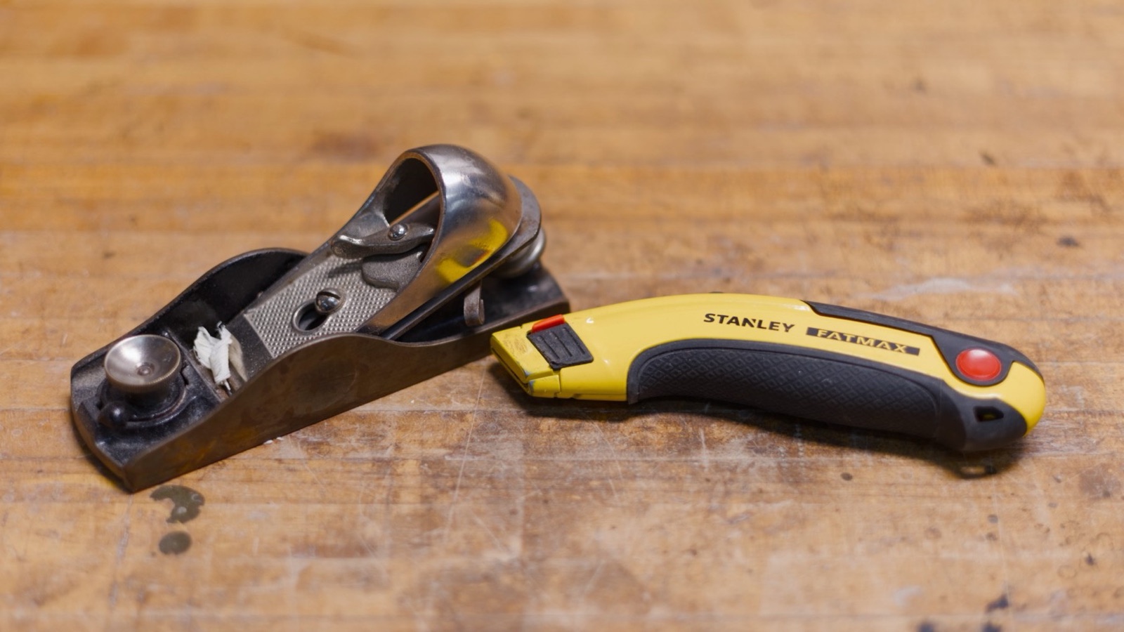 An old Stanley hand plane beside a Stanley utility knife